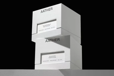 Two stacked white square candle boxes featuring black Aather typography against a stark black background.