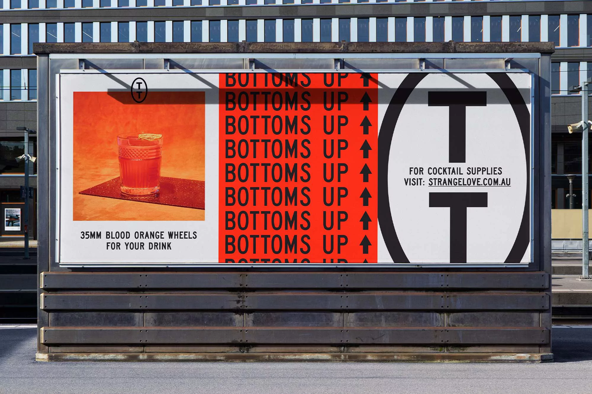Outdoor advertising billboard featuring a cocktail in a glass, text “Bottoms Up”, and the address strangelove.com.au.