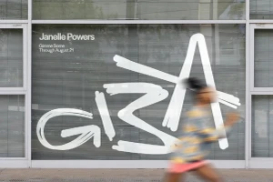 Motion-blurred figure running past a glass storefront bearing large white graphic lettering for Guilty by Association