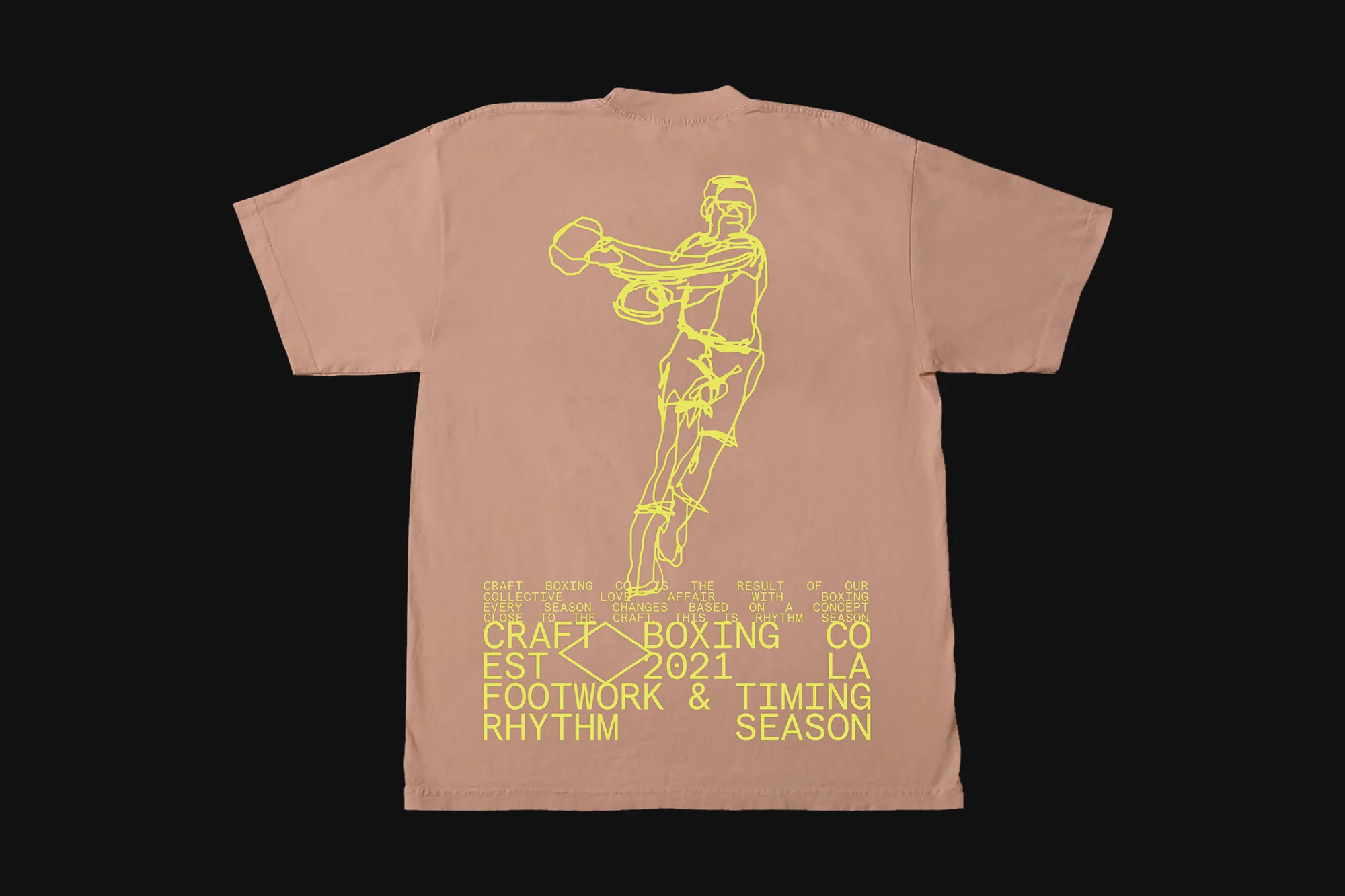 Back of a light brown t-shirt featuring a yellow graphic of a boxer and text related to boxing. Fashion apparel close up shot.