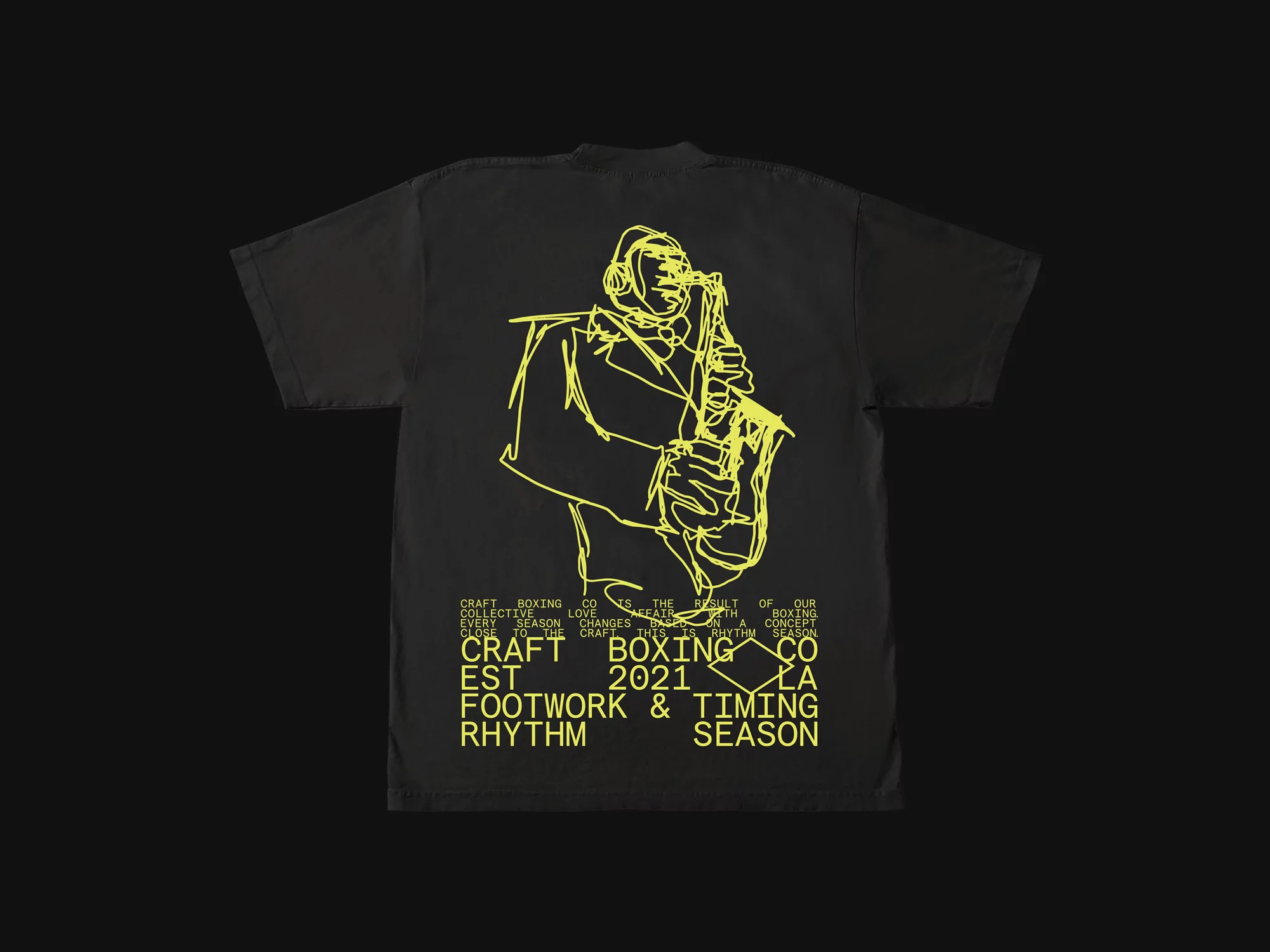 Black t-shirt with a yellow line drawing of a saxophone player, plus text that says Craft Boxing Co., Footwork & Timing, Season.