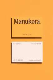 Manukora brand identity presentation featuring two business cards resting on a solid yellow textured surface.