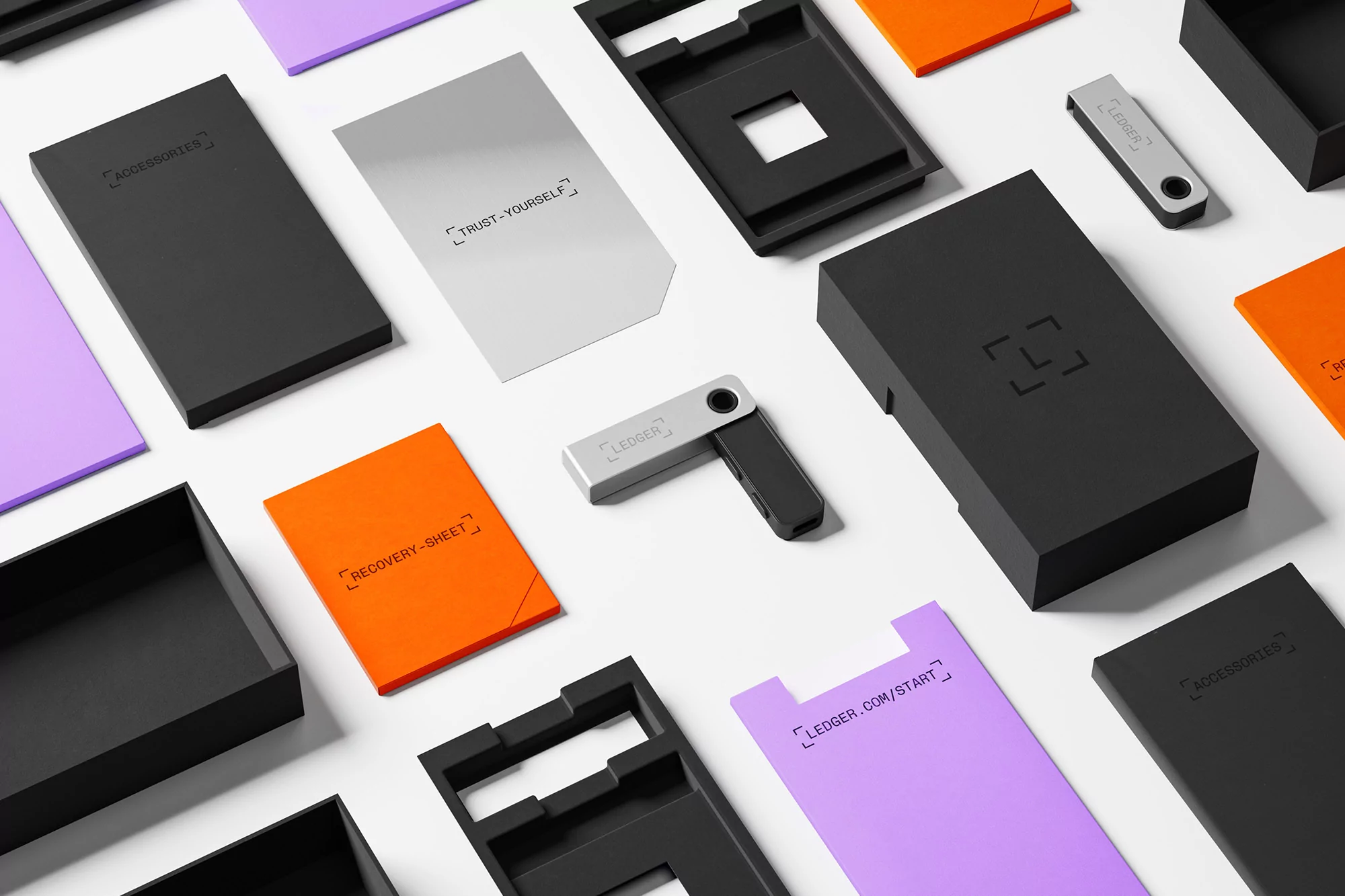 Ledger Nano X crypto wallet and packaging, including accessories and recovery sheet, flat lay on a white background.