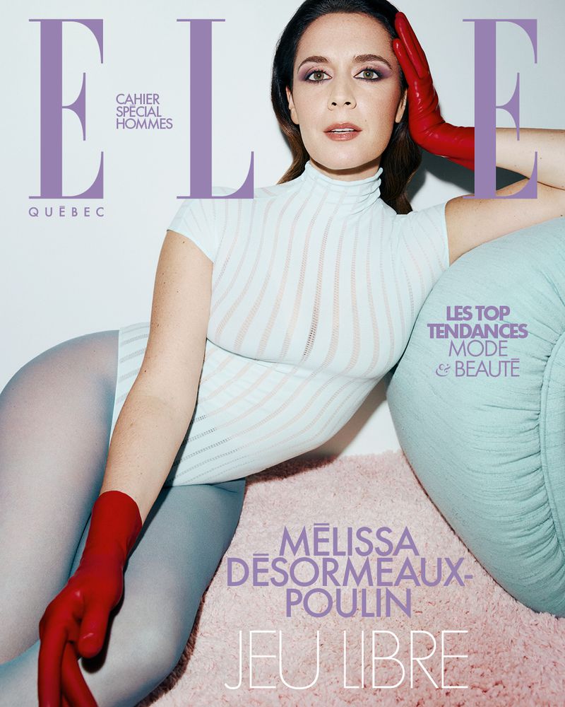 Magazine cover featuring a woman in a bodysuit and red gloves, posing on a pink rug with a light blue cushion, with 'ELLE' in the masthead.