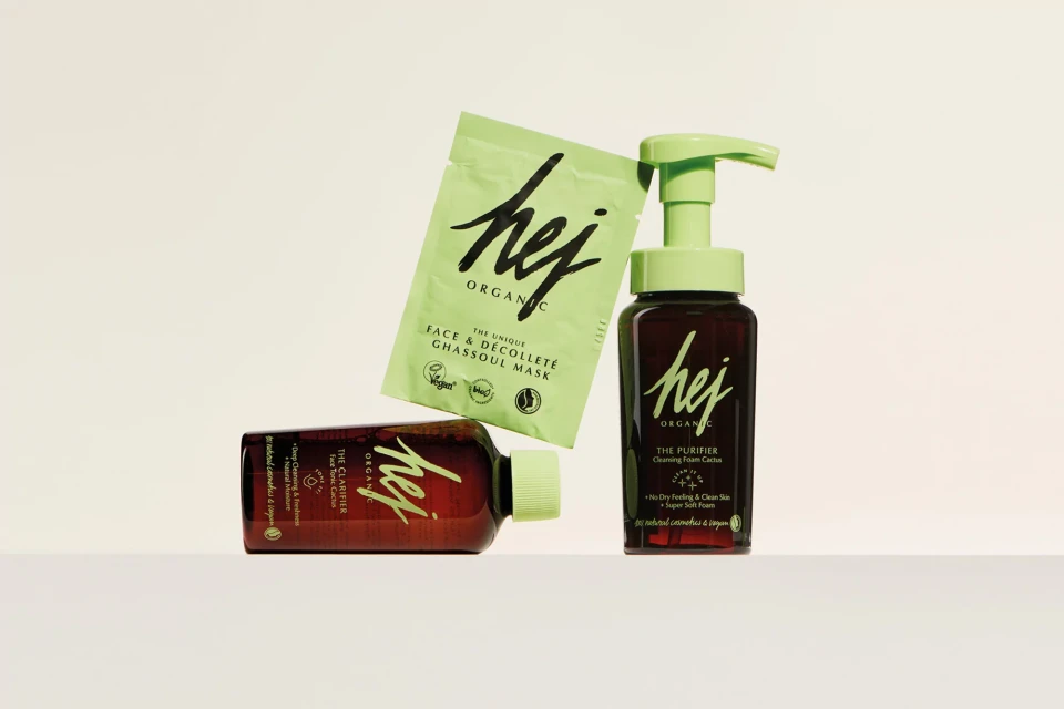 Hej Organic skincare product line featuring a face mask and cleanser bottles, showcasing natural ingredients and clean beauty focus, studio shot.