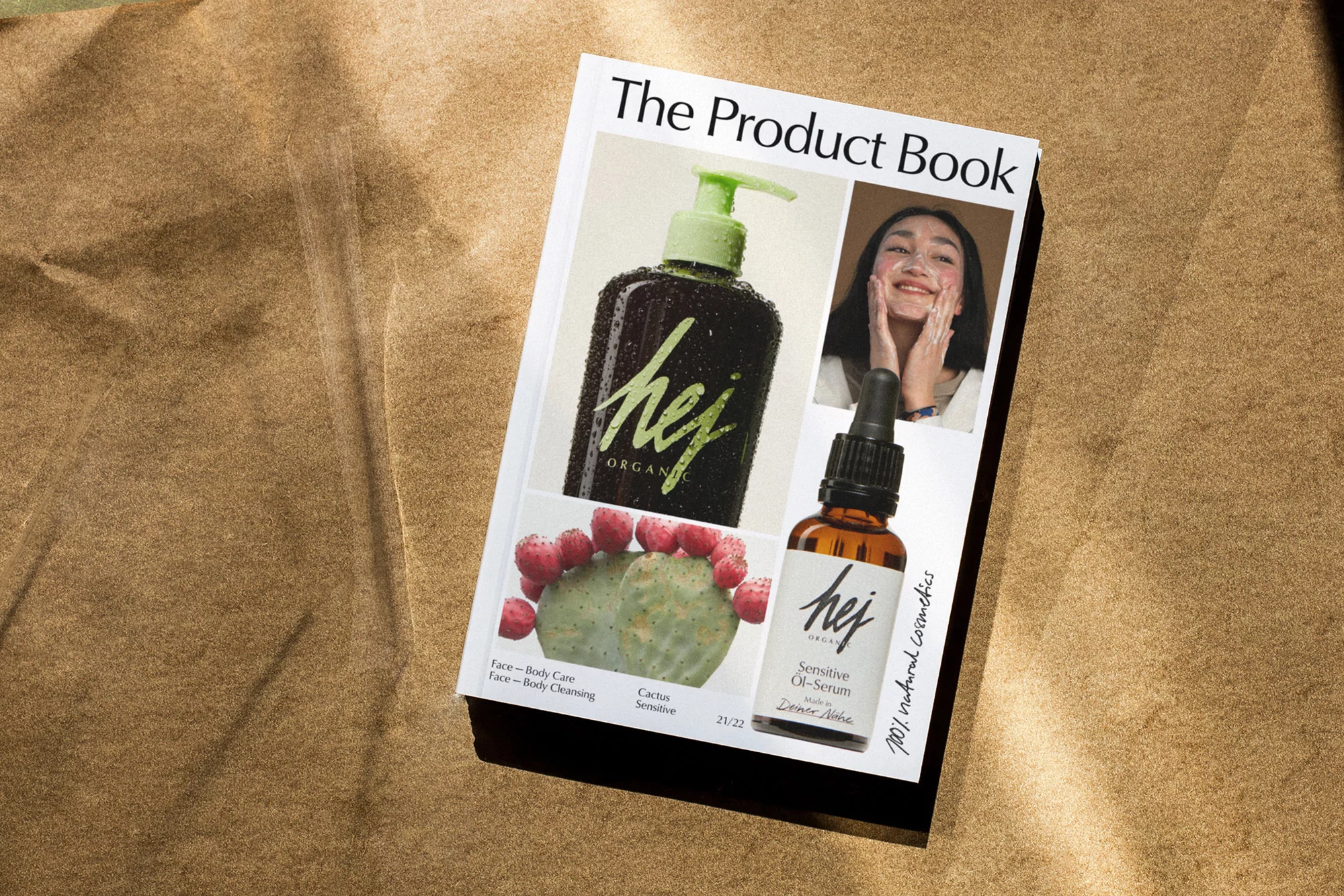 A product book displaying images of the organic cosmetics brand, hej. The page features product images, a cactus, and a smiling woman.