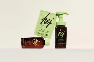 HEJ Organics skincare products including a pump bottle, a tonic bottle and a green face mask sachet on a neutral white background