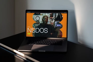 A laptop displaying the Echio brand website showing a graphic interface with a portrait of a man and bold typography.