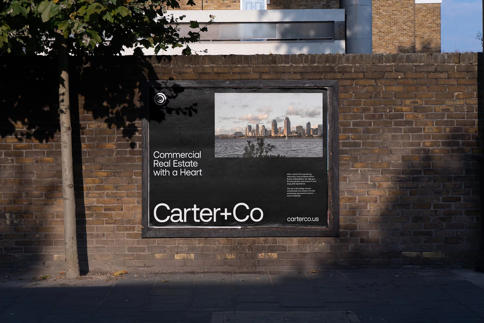 Outdoor advertising billboard on brick wall features a cityscape and 'Carter+Co' logo, promoting commercial real estate services.