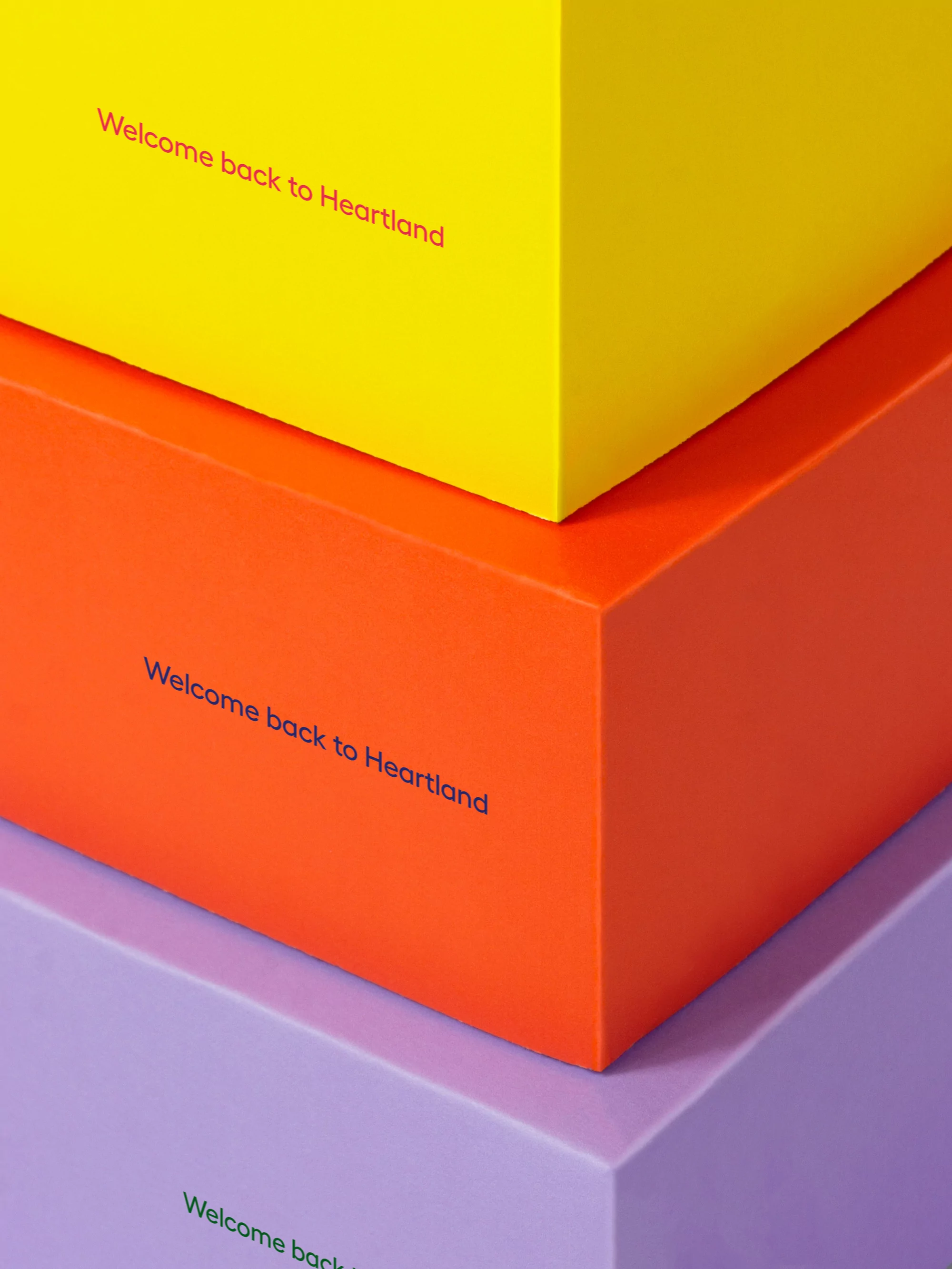 A stacked arrangement of yellow, orange, and purple rectangular boxes, each labeled with 'Welcome back to Heartland' in small red lettering.