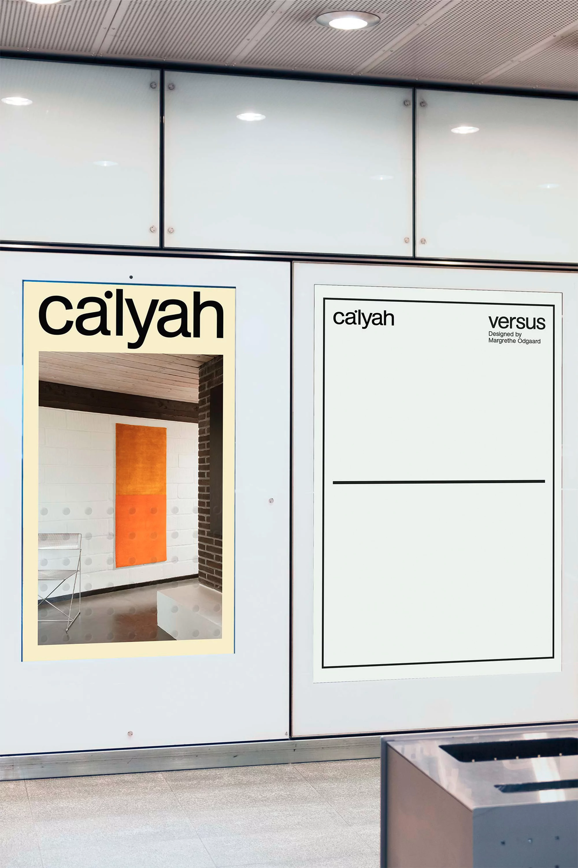 Two 'caiyah' advertisement posters are mounted on a white wall, featuring interior design and minimalist graphic design in an indoor space.