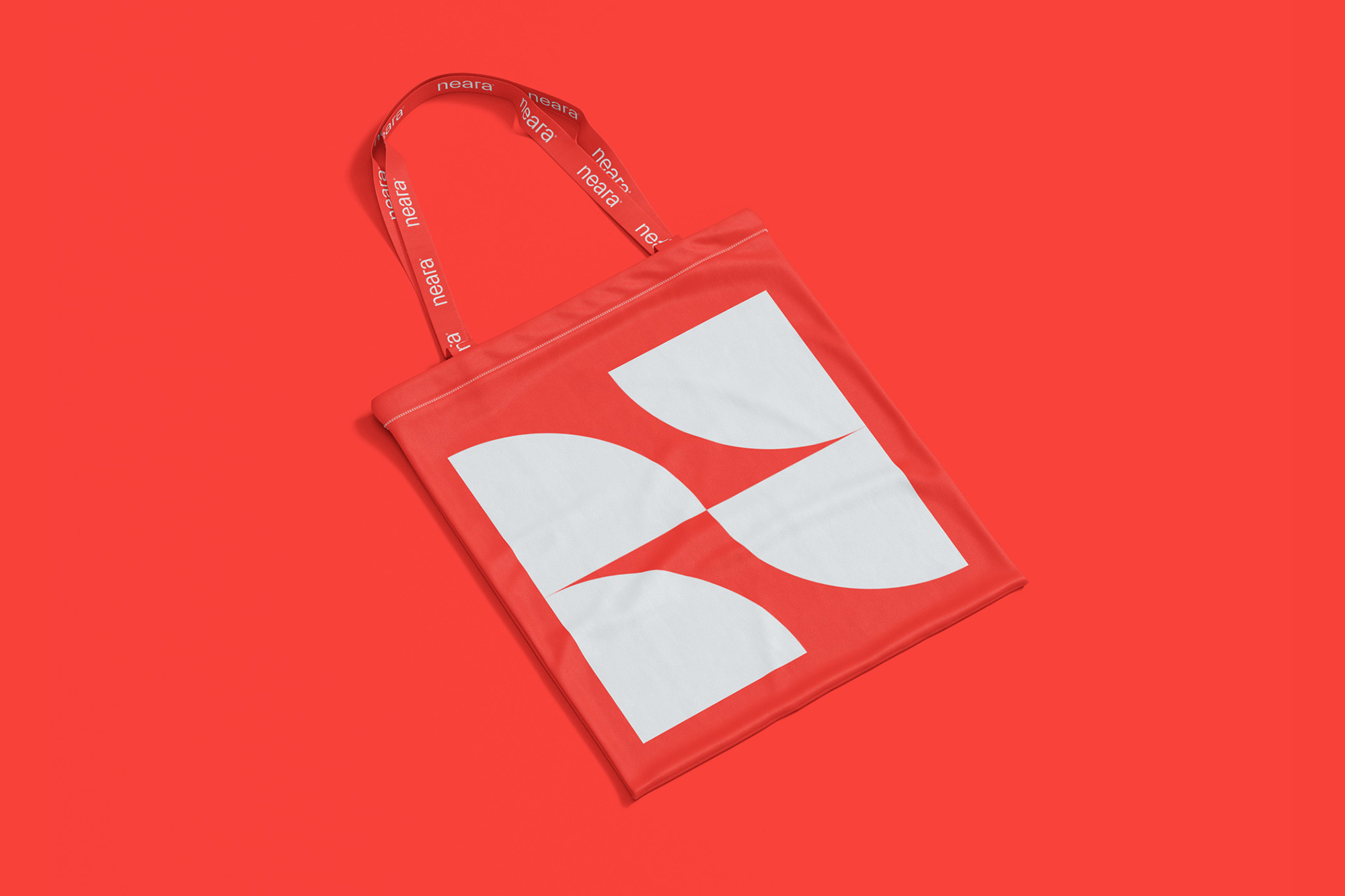 Red tote bag with white logo on a matching red background, showcasing a clean product shot for branding or promotional use.