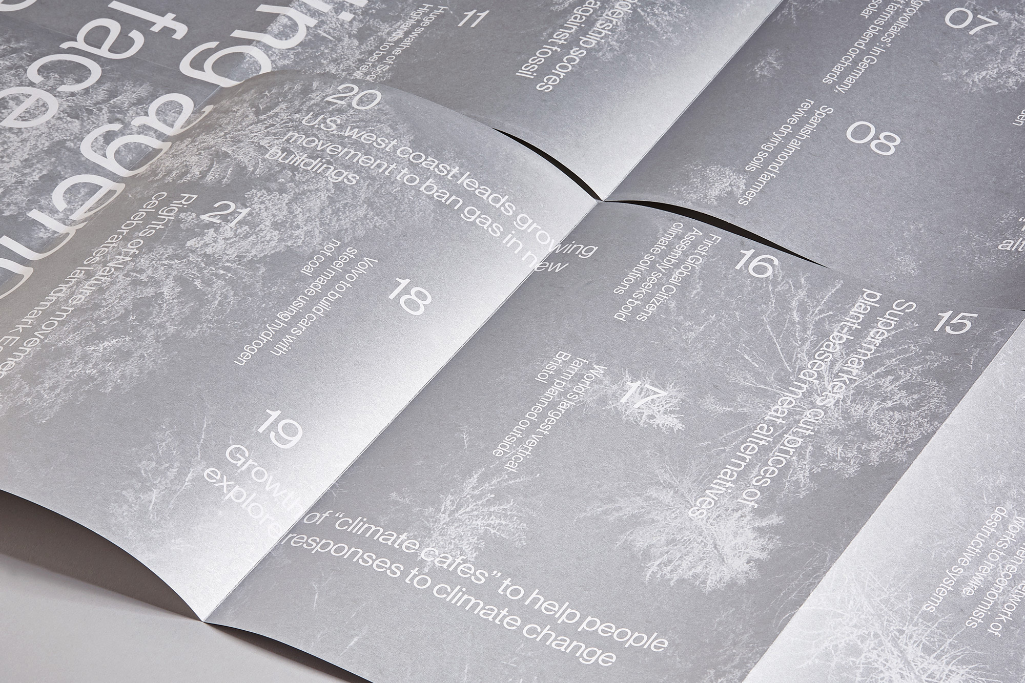 Close-up of an open magazine featuring articles on climate change and sustainability, including topics like renewable energy and plant-based alternatives.