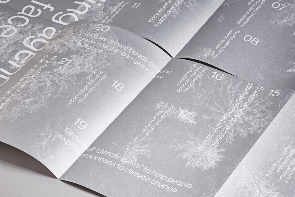 Close-up of an open magazine featuring articles on climate change and sustainability, including topics like renewable energy and plant-based alternatives.
