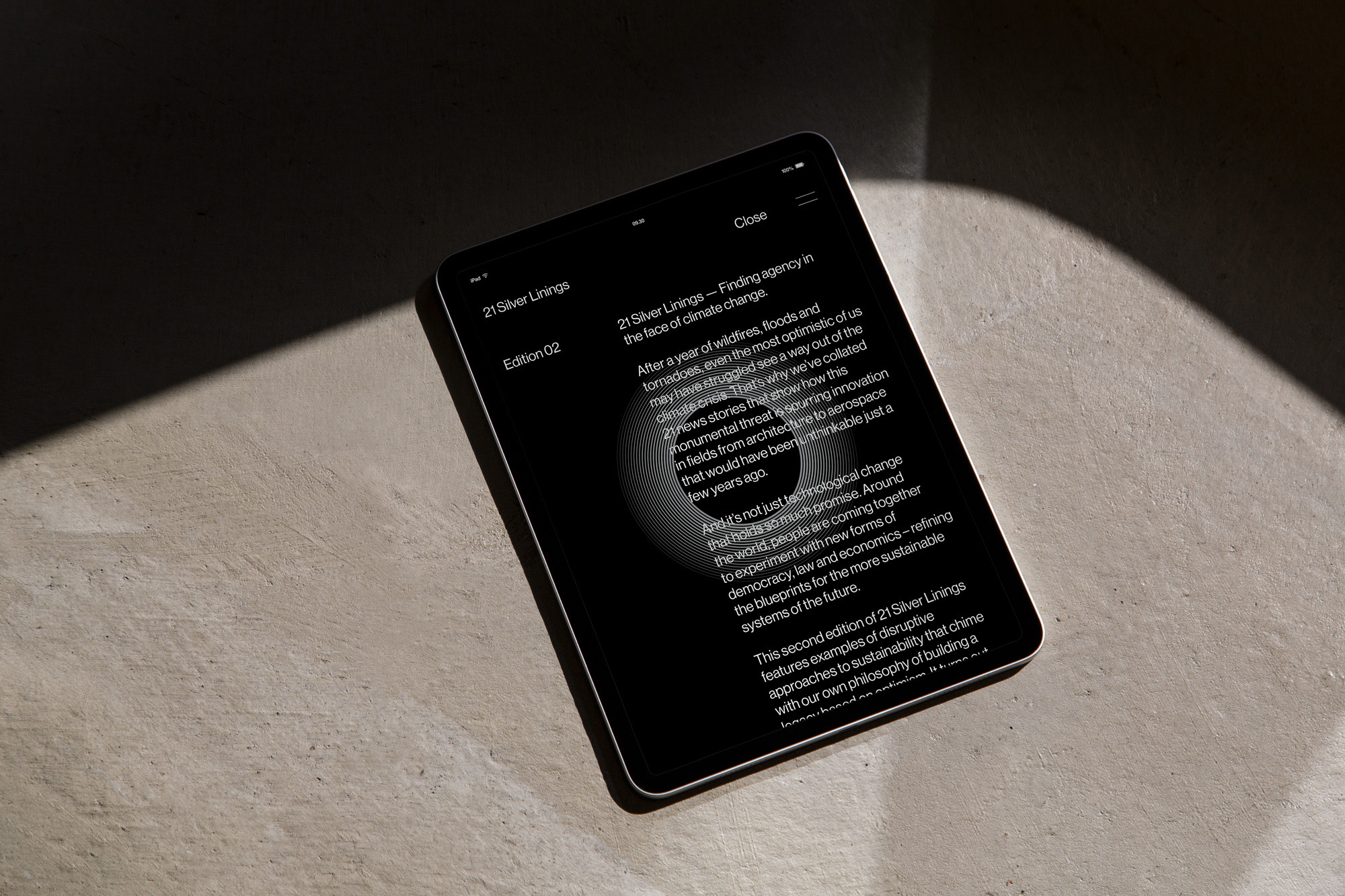 Digital tablet on textured surface displaying graphic design publication titled '21 Silver Linings' focused on climate change solutions.