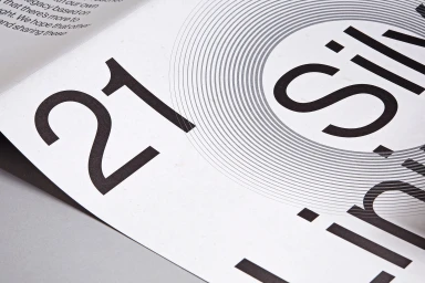 Close-up macro shot of printed paper featuring large typography number twenty one and concentric graphic circles