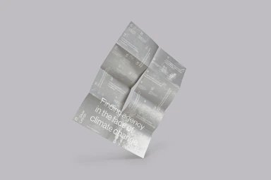 Folded grey printed brochure leaflet floating diagonally against a neutral grey studio background.