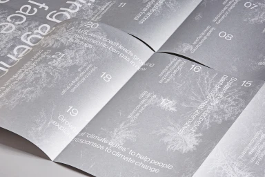 Open printed publication pages in grey tones featuring typography and numbered sections on a plain white background