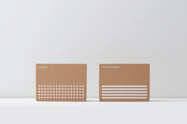 Two brown cardboard boxes with white printed graphics set against a clean white seamless studio background.
