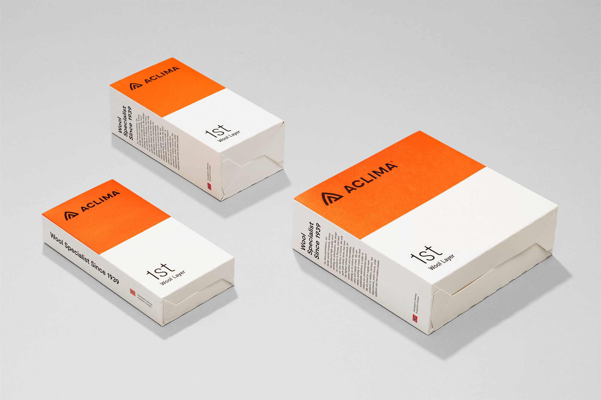 Three white boxes with an orange stripe and 'ACLIMA' logo are angled against a gray background in a studio product shot.