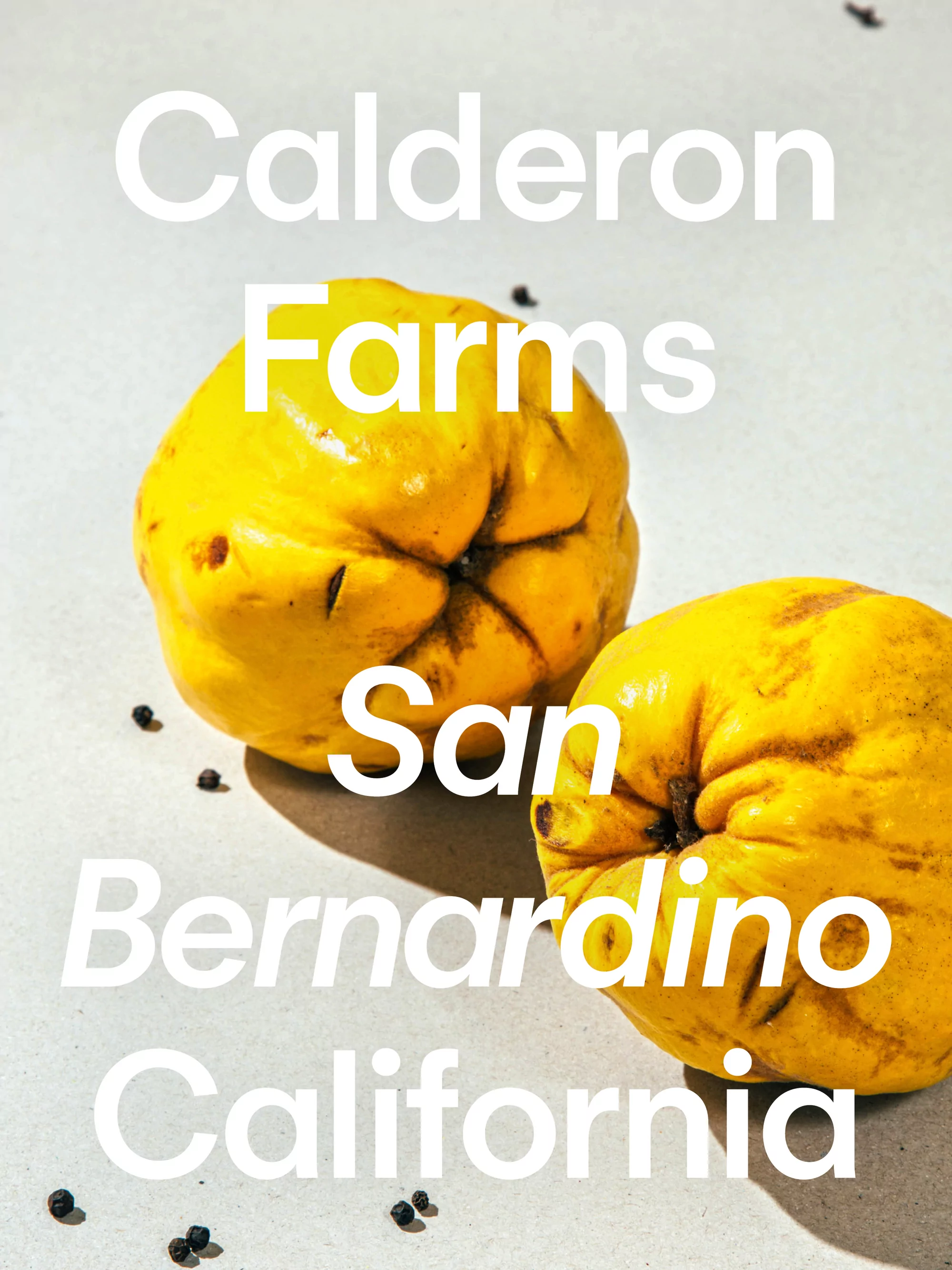 Two yellow quinces are arranged on a light surface, scattered with black peppercorns, beneath white text reading 'Calderon Farms.'