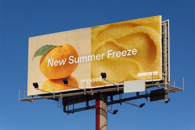 Billboard advertisement featuring citrus fruit and the words 'New Summer Freeze' against a clear blue sky in an outdoor setting.