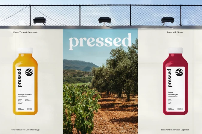 Pressed juice billboard featuring orange turmeric cold-pressed juice and roots with ginger juice, displayed against a landscape backdrop.