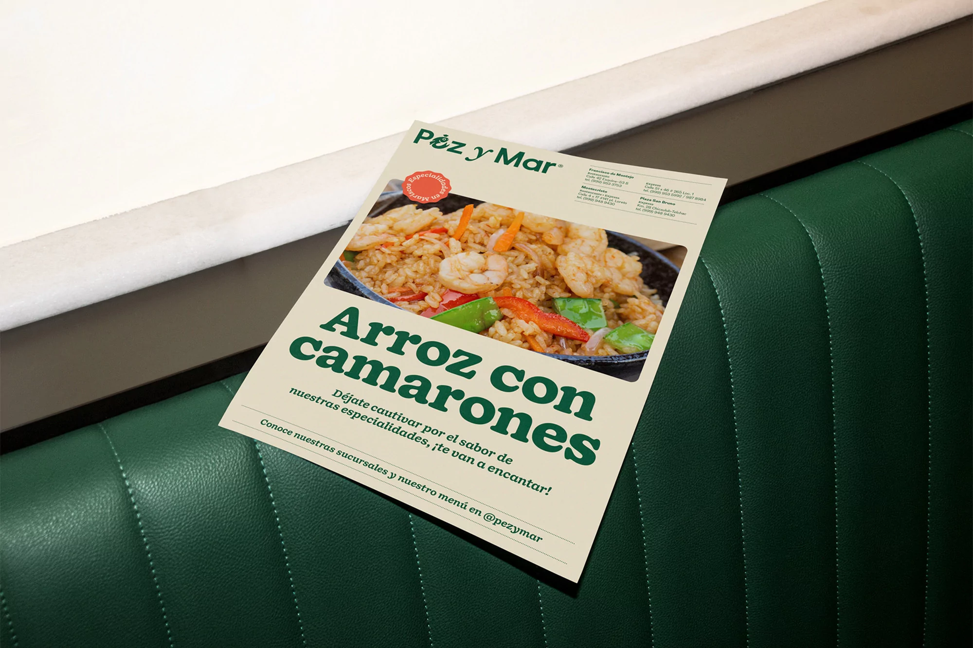 Eye-level shot of a Pez y Mar restaurant advertisement featuring a rice and shrimp dish, placed on a green textured restaurant booth.