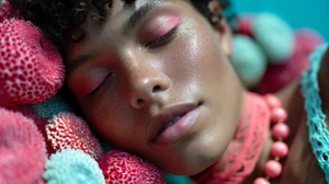 Close-up portrait of a model with pink eyeshadow and closed eyes surrounded by textured coral-like props for Miami Swim Week