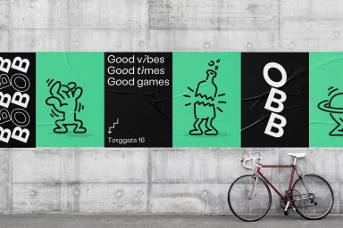 Posters with black and green graphics mounted on a textured concrete wall above a parked red bicycle.