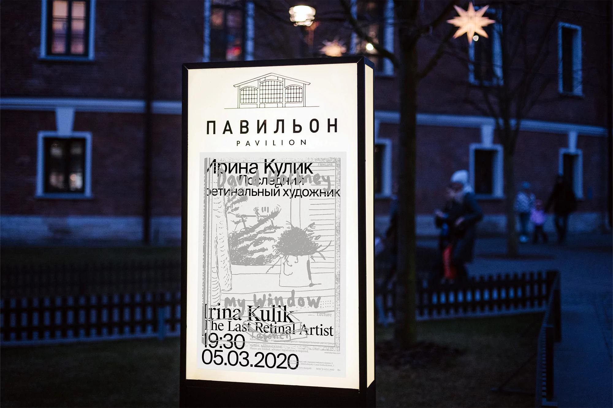 Illuminated sign for Irina Kulik art exhibition at Pavilion, featuring a drawing, set against a brick building at night.
