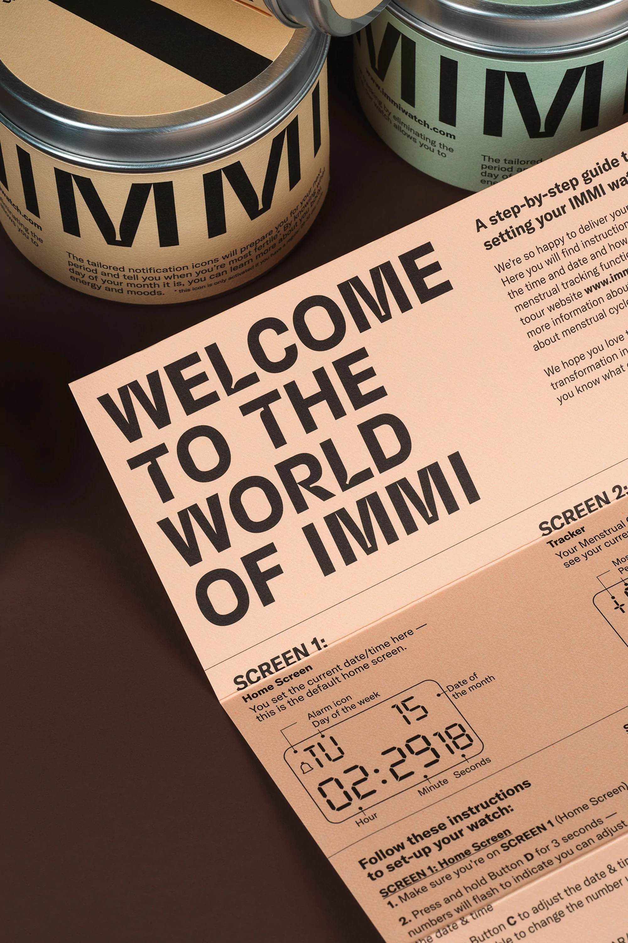 Promotional shot featuring IMMI product cans and an instruction sheet, showcasing IMMI branding and information on a dark surface.