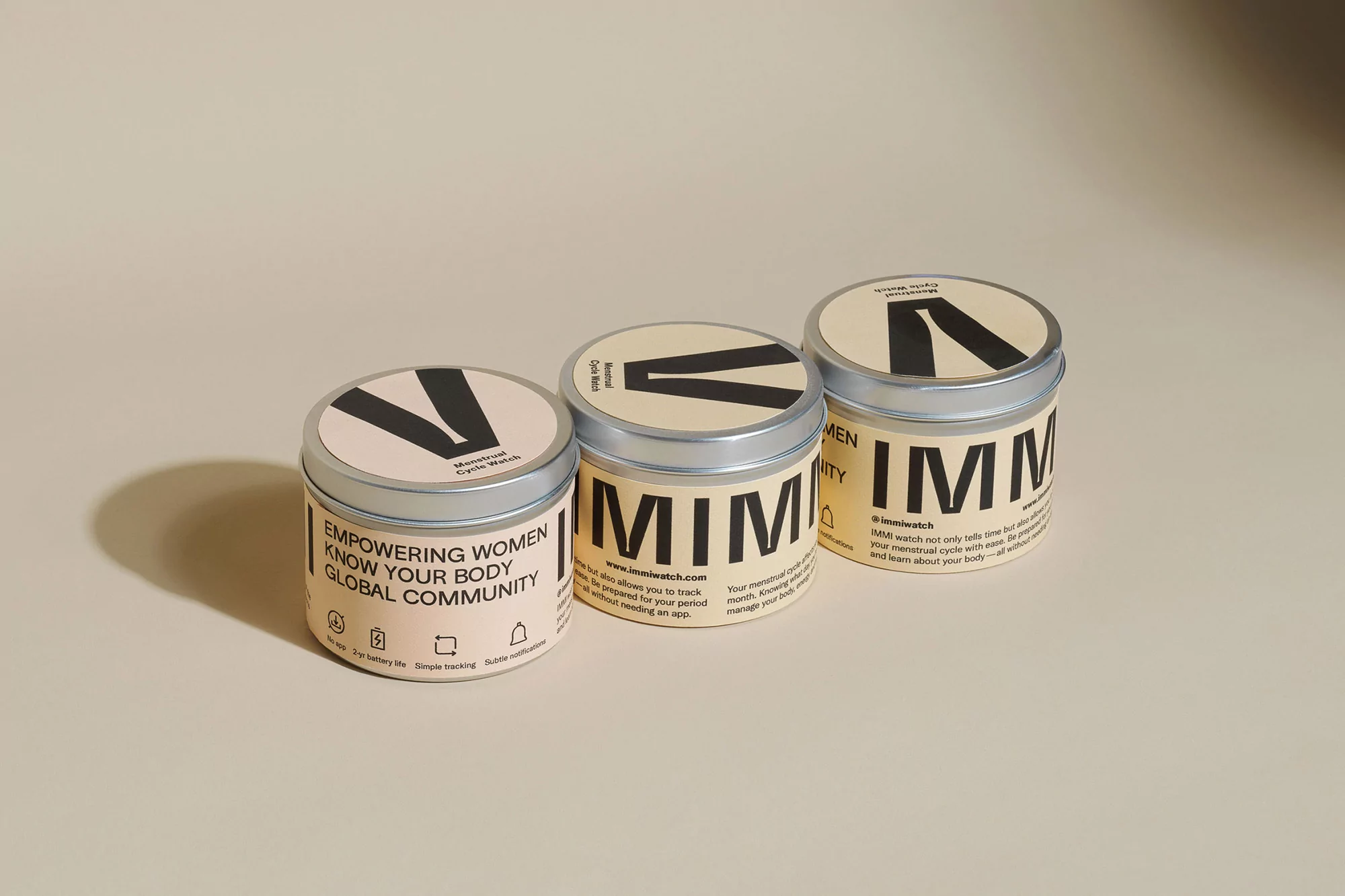 Three tin containers with minimalist branding, arranged on a light background, present a clean and modern aesthetic for product display.