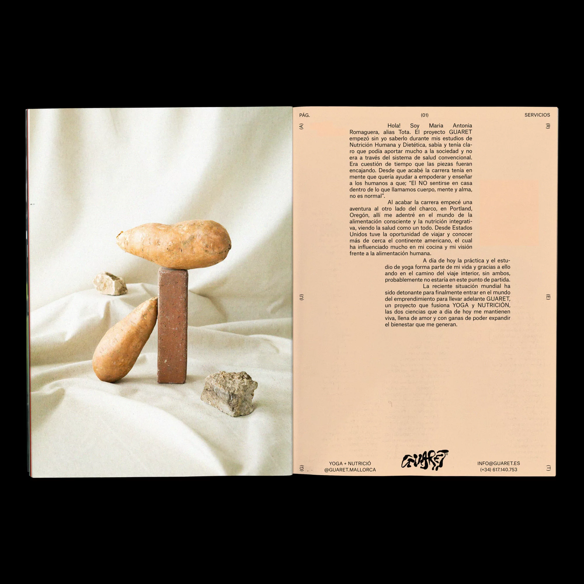 Still life with sweet potatoes balanced on a brick and rocks on a white cloth background, accompanied by text pages.