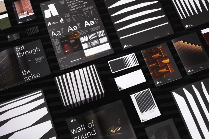 Collection of printed graphic design marketing materials with black and white designs including brochures, posters, and cards.