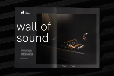 An open brand catalog for Autex Acoustics displaying large white typography reading wall of sound and an image of a person operating a synthesizer.