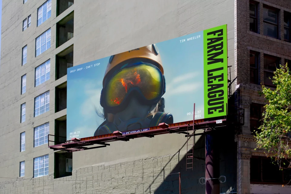 Billboard ad for Farm League featuring close-up of person in yellow helmet and face mask against bright sky and urban background.