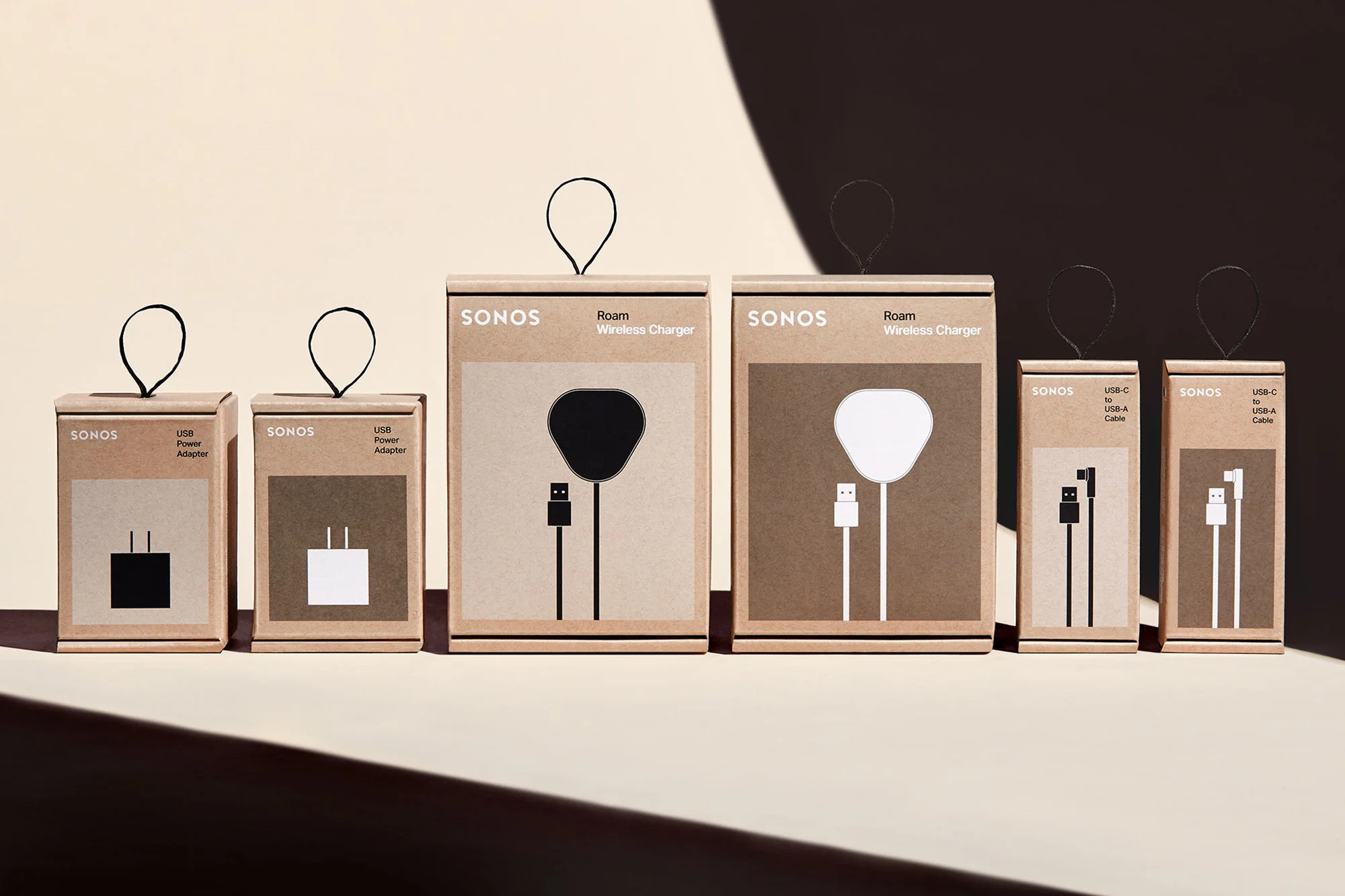Product shot of Sonos Roam wireless chargers and USB power adapters in their original packaging against a light beige background.
