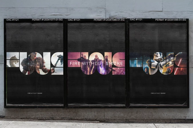 Three black poster panels mounted on a grey concrete wall displaying large typographic graphic art with embedded imagery.