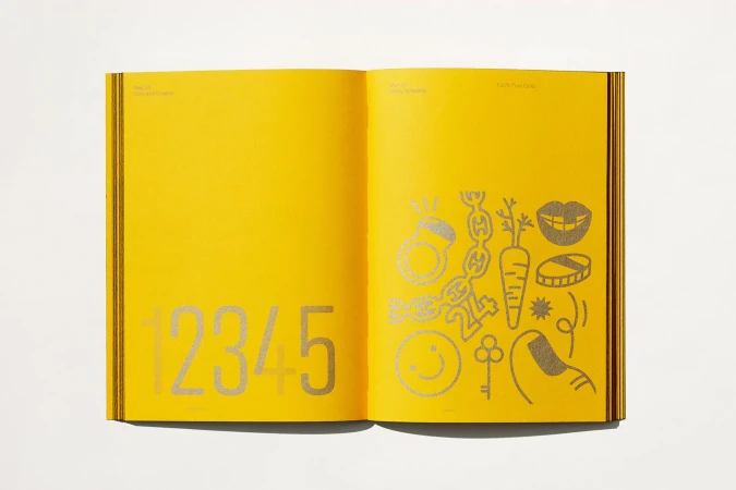 Open book displaying yellow pages with silver illustrations and numbers, creating a graphic and modern design.
