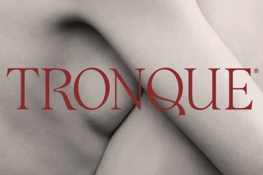 Close-up monochromatic view of smooth skin contours with bold red typography reading TRONQUE layered across the center.
