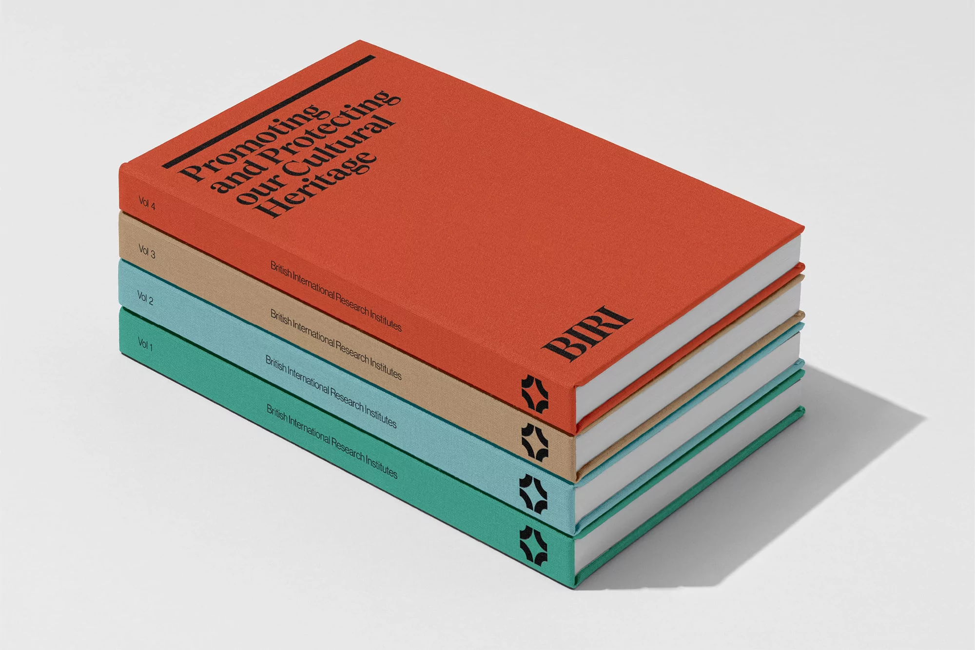 Stack of four textured hardcover books in orange, beige, light blue and green with black text, set against a white backdrop.