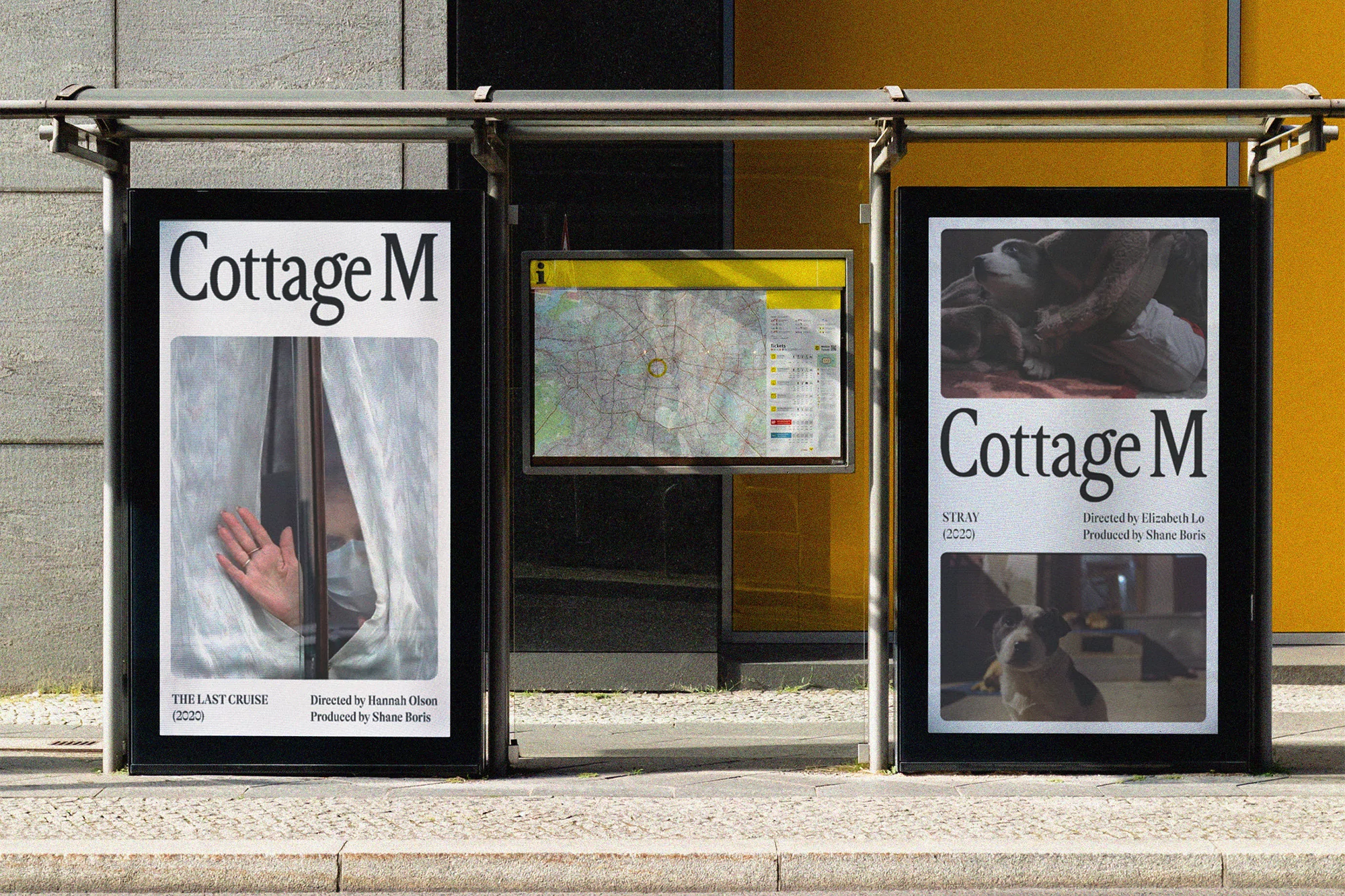 Bus stop in urban setting with movie posters for Cottage M film series, displayed on either side of a public transit map.