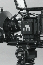 Professional cinema camera rig mounted on a tripod against a neutral grey background for Cottage M brand identity