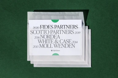 Transparent vellum envelopes stacked on a deep green textured background containing printed text cards
