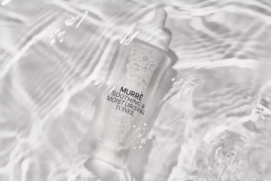 Murre soothing and moisturising toner bottle submerged in clear rippling water with soft light reflections