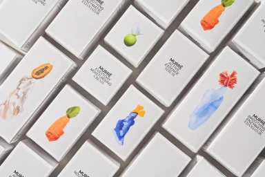 Top-down view of white MURRE skincare product boxes featuring botanical and abstract watercolour illustrations arranged diagonally.