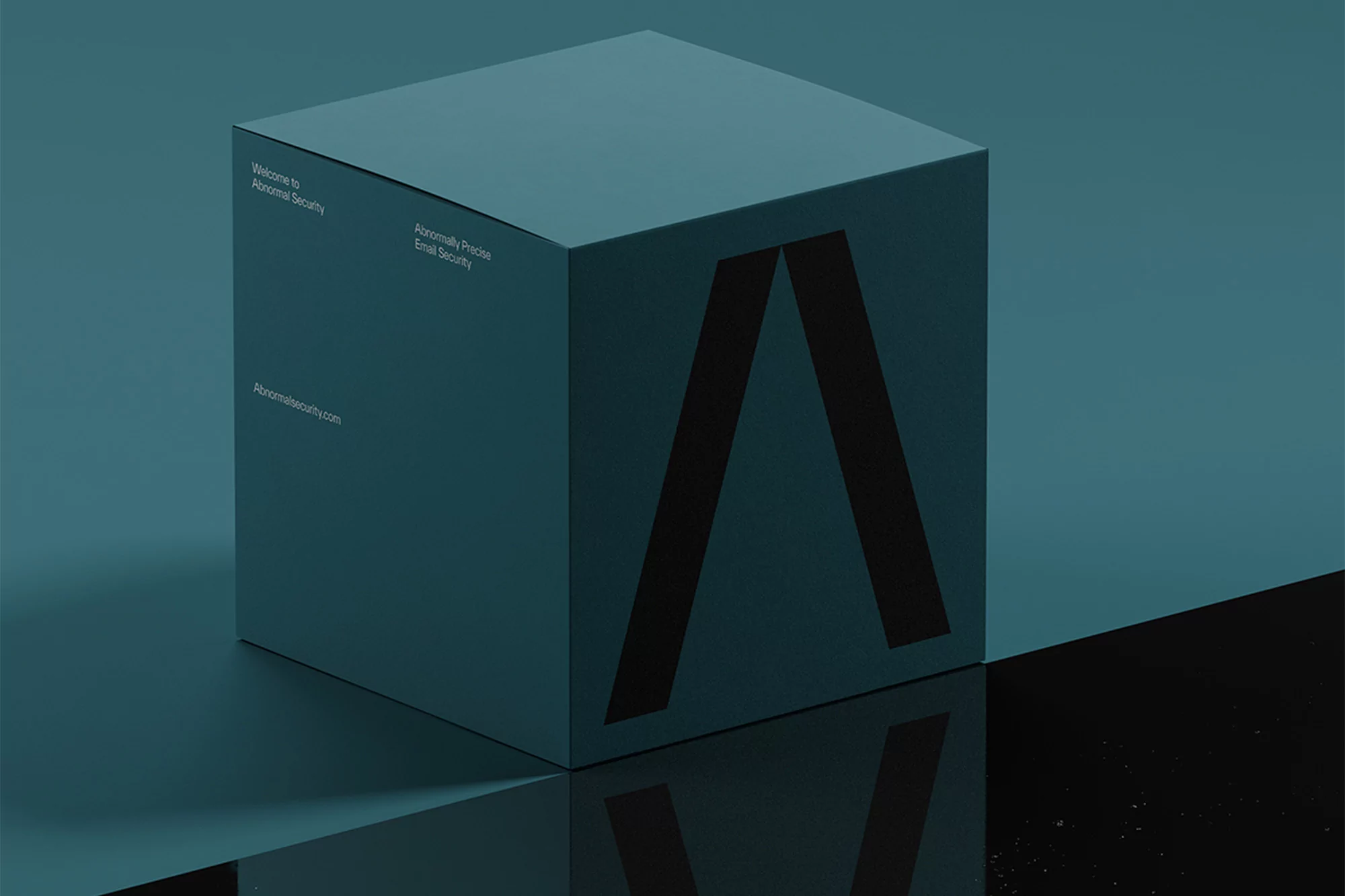 A teal-colored cube featuring a stylized 'A' logo and company information against a matching backdrop, creating a minimalist tech aesthetic.