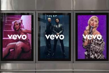 Three vertical digital billboard screens displaying Vevo brand identity campaigns featuring different musical artists against styled backgrounds.