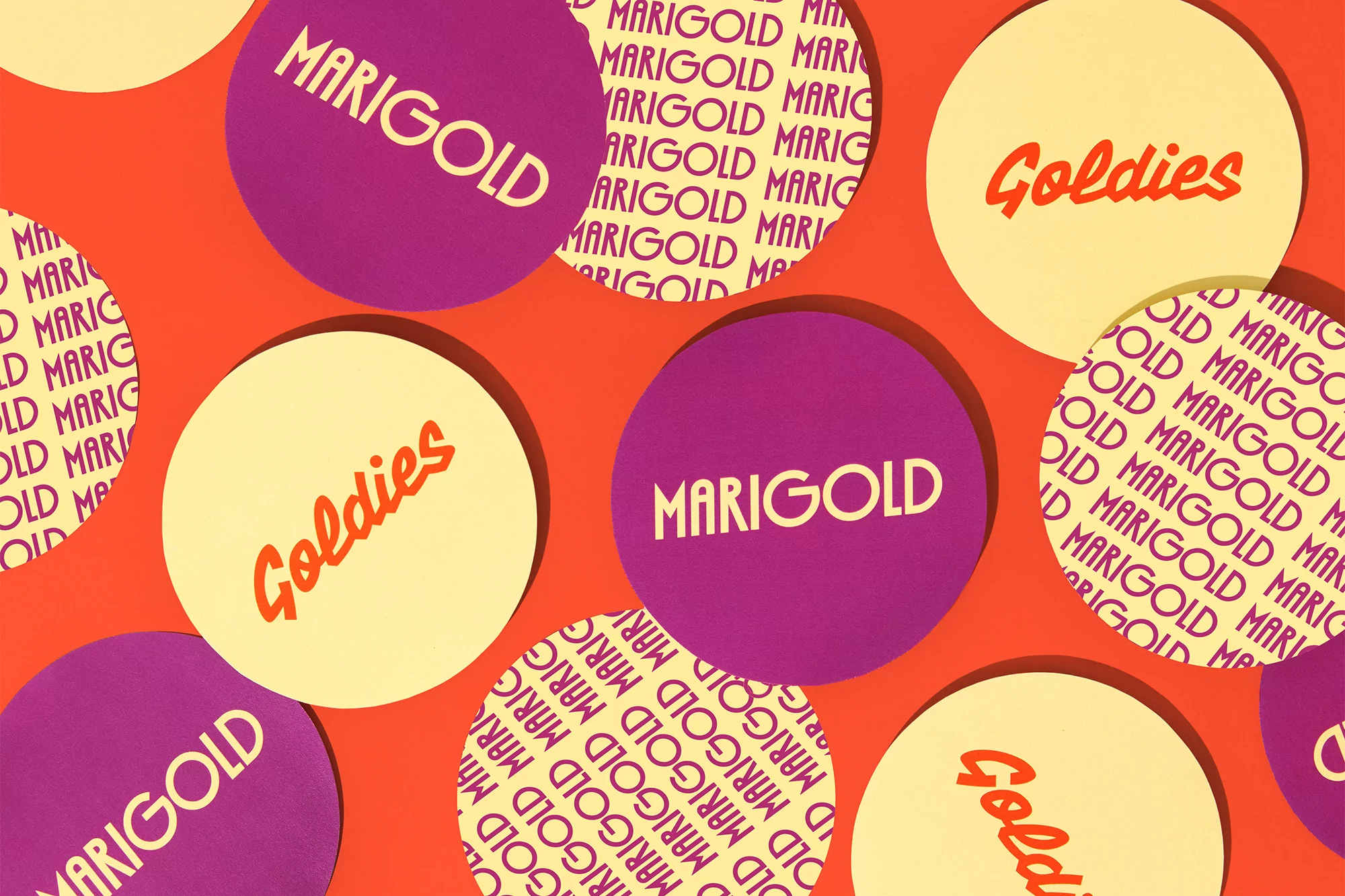 Overhead shot of yellow and purple circles featuring 'Goldies' and 'Marigold' texts against a bold orange background, pattern design.